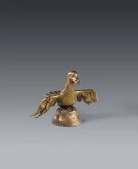 Maasland, A bronze eagle, presumably Meuse region, 14th-15th century, Cast and engraved bronze, the front of the eagle with presumably later gilding. Small model of an eagle with outstretched wings, designed in a similar manner to a lectern. With drilled holes on the back, presumably for a small book stand. The eagle's right talon lost, a small breakage to the underside. Presumably later attached to a tapering bronze plinth