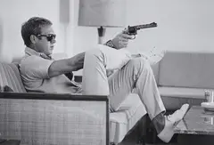 John Dominis, Steve McQueen Aims a Pistol in His Living Room, CA, 1963, Posthumous gelatin silver print, printed