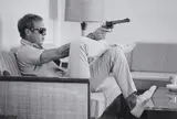 John Dominis, Steve McQueen Aims a Pistol in His Living Room, CA, 1963, Posthumous gelatin silver print, printed