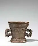 Werkstatt Hachmann, A Hachmann mortar made for Johan Linit, Golden brown cast bronze with rich chocolate brown patina. The display side decorated with a vacant coat-of-arms supported by winged demi-figures. With two wide banderoles below the rim and above the base inscribed in Gothic minuscule: “johan linit ? so got furh my ghenuch” and “int iaer ons heren m vc lxviii”. The handles formed as double-headed dragons. H 12.8, D