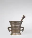 Werkstatt Hachmann, A rare Hachmann mortar and pestle, Golden brown cast bronze with chocolate brown patina. Decorated on both sides with shields supported by winged demi-figures and putti bearing "house marks". Inscribed below the rim and above the base in Gothic minusculae on wide banderoles: "cuimera ruddenscheitz myn hape steit in godt", and "int jaer ons heren m vc lxxiiii". With two zoomorphic handles. Associated double pestle with nodus, engravings and beautiful identical patina. With minor dents around the rim. H 13.5, D