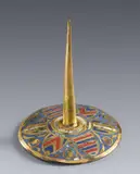 Limoges first half 13th century, A cast bronze travel candlestick, Cast bronze with engraved, gilded and enamelled decoration. The round, slightly domed base of the candlestick emblazoned with six coats-of-arms, whereby the opposites of which correspond. The spandrels decorated with curving gold foliate scrolls against blue ground. The pricket rises directly from the centre of the base, surrounded by concentric circular bands. A similarly decorated but slightly taller Limoges enamel candlestick dating from the 13th century is housed in the Kunstgewerbemuseum (inv. no. K 4197) of Staatliche Museen zu Berlin. Further, almost identical candlesticks are in the collection of the Louvre in Paris (Inv.Nos. MR 2660 - 2665). Minor surface abrasions, minor losses to the enamel