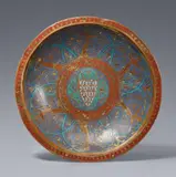 Limoges first half 13th century, An enamelled bronze dish with the French coat-of-arms, Rolled, embossed bronze with engraved, gilded and enamelled decoration. A finely worked dish displaying a balanced composition using the contrast of the polychrome enamels against the gilding to provide an impressive overall impression. The border picked out in red with an angular gold frieze. The lip decorated with a frieze of six women in courtly attire shown in dancing poses against blue enamel ground encompassed by turquoise arches and delicate gold tendrils. The centre of the bowl decorated in the same colours and reiterating the designs of the rest but with a central quatrefoil motif surrounding a heraldic shield. The coat-of-arms with gold lilies on pale blue ground is that used by the French royal family under Philippe Auguste II (1179-1223), Louis VIII “The Lion” (1223-1226) and Louis IX “The Saint” (1226-1270). In good overall condition. The lip with two small drilled holes. With dents, abrasions, and minor losses to the enamel