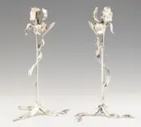 Léopold van Strydonck, A pair of silver-plated bronze lily lights, Silver plated bronze. Cast in one chased, engraved and polished. Designed as iris flowers, the four-sided candle prickets in the centre of the blooms and the three curved leaves forming the feet. H