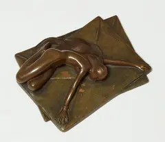 Michael Drobil, A bronze paperweight, Bronze with high copper content and golden brown patina. Depicting a nude woman lying on an oversized letter with her arms stretched out to hold further correspondence. Engraved signature "DROBIL"