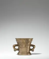 Werkstatt Hachmann, A small dated Hachmann mortar, Golden brown cast bronze with polished natural patina. The display side decorated with a vacant coat-of-arms supported by winged demi-figures. Inscribed below the rim in Gothic minuscule: “anno domini m ccccc lxi” and “myn hape steit allein in godt”. With two zoomorphic handles. Severely worn, dents around the rim. H 11.2, D