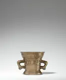 Werkstatt Hachmann, A small dated Hachmann mortar, Golden brown cast bronze with polished natural patina. The display side decorated with a vacant coat-of-arms supported by winged demi-figures. Inscribed below the rim in Gothic minuscule: “anno domini m ccccc lxi” and “myn hape steit allein in godt”. With two zoomorphic handles. Severely worn, dents around the rim. H 11.2, D