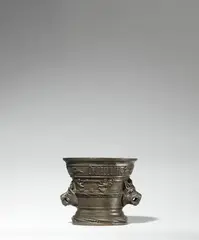 Werkstatt Hachmann, An important museum quality mortar by Albert Hachmann, Cast bronze with fine chocolate brown patina. Of tapering form with a tiered base decorated with beading. One side with a vacant coat-of-arms supported by winged demi-figures. Dated in Gothic minuscule below the rim: “anno domini m ccccc xlviii”, with a running hare, a hunting dog, a sun, and a flower between. The handles formed as the heads of wolves, originally holding rings in their snarling maws. Some minor dents around the rim, later scratches to the base. H 11.4, D