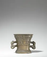 Werkstatt Hachmann, A dated Hachmann mortar, Golden brown cast bronze with natural patina. The display side decorated with a vacant coat-of-arms supported by winged demi-figures. With two wide banderoles below the rim and above the base inscribed in Gothic minuscule: “int iaer ons heren m vc lxxvi” and “myn hape steit allein in godt”. With two zoomorphic handles. Minor dents throughout. H 13, D