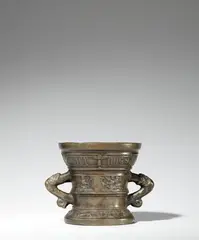 Werkstatt Hachmann, A later Hachmann mortar with an inscription, Golden brown cast bronze with natural patina. The display side decorated with a vacant coat-of-arms supported by winged demi-figures. With two wide banderoles below the rim and above the base inscribed in Gothic minuscule and Latin capital letters: “int iaer ons heren m vc lxxxiiii” and “IN DEO SPES MEA”. With two zoomorphic handles. Some abrasion, minor cracks and dents to the inner surface and around the rim. H 13.2, D