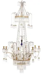 Werner & Mieth, An opulent Berlin chandelier, Gilt and silver-plated bronze and metal, cut clear and cobalt glass. Eight-flame chandelier with pierced drip pans suspending lamps in the upper section, below it two smaller pierced rings, the central one of which with a horizontal blue glass disc. The blue central spindle surrounded by eight chains, above it a further curved ring suspending eight lamps. Hung from four chains. All rings, drip pans and lamps fully hung with largely original droplets. The central spindle restored, the chain connecting to the central spindle replaced, the drip pan below it presumably a later addition, the fine strand of beads surrounding it and the rhomboid droplets presumably also. H c. 150, W