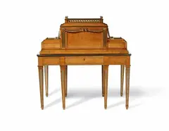 An Imperial writing desk by David Roentgen, An Imperial writing desk by David Roentgen, Thuja wood veneer on mahogany and oak corpus, ormolu and brass mountings. Multi-functional table on eight removable tapering supports of square section decorated on four sides with milleraie motifs. Straight apron with central drawer beneath a sliding top surrounded on both sides by a low bronze gallery. The architectural upper section with a large central compartment closed by a sliding blind and flanked by two shallow side compartments, each with a drawer with a spring mechanism. The right drawer with three compartments for inkwells. The top conceals two levers to open the drawers which extend out on either side. The entire piece decorated throughout with finely grained symmetrical wood veneer, the edges with beaded borders, each of the angles of the central compartment accentuated by brass-filled fluted motifs beneath rosette appliques. The central compartment surmounted by a gallery with pierced circular motifs and eight small baluster-form vase finials. The four central supports and the laurel swags supported by the rosettes of the central compartment are later additions. H 112, W 113, D