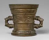 A Hachmann mortar made for Philip Pheuenruten by A Hachmann mortar made for Philip Pheuenruten, Yellowish gold cast bronze with natural patina. The display side decorated with two demi-figures supporting a vacant shi, sold May 2020