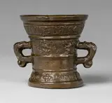 A small Hachmann mortar made for Hanrich Katryn Bats by A small Hachmann mortar made for Hanrich Katryn Bats, Cast bronze with chocolate brown patina. The display side decorated with winged demi-figures supporting a shield with a , sold May 2020