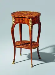 A side table from the studio of the Gebrüder Spindler, A side table from the studio of the Gebrüder Spindler, Palisander, kingwood, amaranth, walnut, maple, and stained wood veneers, partially engraved and with black contours, on oak corpus, ormolu and brass mountings. Four slender curved supports of square section with pronounced knees supporting an apron with three slightly convex faces and one slightly concave face, one drawer to the right concealing a metal inset divided into three compartments with embossed decor. Both tops and the apron finely inlaid with flowering tendrils. With well-fitting original bronze mountings consisting of an almost complete moulded border and flowerhead relief appliques to the knees. Some smaller old restorations, the hinges replaced. H 69, W 40.3, D
