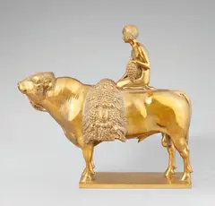 Ignatius Taschner, Allegory of Agriculture, Cast from bronze with high copper content and gilt. Depicting a girl seated on a bull holding a large bunch of grapes and with a bundle of grapes and fruit before her. Engraved to the upper left of the plinth "J. TASCHNER", stamped to the side of the plinth "PRIESSMANN BAUER & CO MUNICH BAVARIA". H