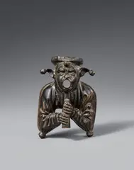 Netherlands second half 15th century, A Netherlandish cast bronze figure of a court jester, second half 15th century, Engraved bronze figure with old patina, hollow reverse. A figure of a man in a fool's cap resting his chin on a flute. The figure's open mouth indicates that it may have originally formed part of a fountain, functioning as a water spout. A very similar counterpiece entered the collection of the Antikenkabinett in Vienna in 1880. That piece was already documented in Ambras in 1596 and is now housed in the Kunsthistorisches Museum in Vienna (op. cit.). Wear to the patin. A soldered repair to the centre of the reverse. Minor wear
