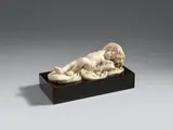 Probably Flemish 18th century, An 18th century marble figure of a sleeping putto, probably Flemish, Carved in the round. Finely carved figure of a putto lying on a cloth holding on to a crown of fruit placed around his head. Predecessors of this composition can be traced back to around 1600. Minimal wear. Mounted on a black marble base