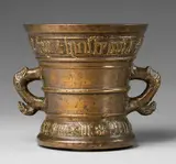 A dated Hachmann mortar, A dated Hachmann mortar, Golden brown cast bronze and slightly mottled remains of patina. Decorated with a vacant shield supported by two winged half figures. Two broad banderoles inscribed in Gothic majuscule surround the rim and the base, above: "johann torricht margrita syn huisfrouw", and below: "int jaer ons heren mvclxxii". The handles designed as stylised dolphins. H 14, D