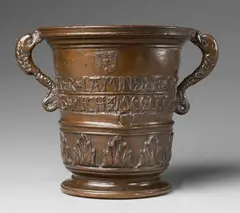 Peter Löffler, A magnificent signed Löffler mortar, Golden brown cast bronze with chocolate brown patina and remains of varnish. Slightly tapering form with pronounced lower section, moulded stepped base and flared moulded rim. The lower section cast with a frieze of large acanthus leaves, above this several mouldings and two banderoles inscribed "PETER LAMINGER VON DEM HAILIGEN KRAIZ" and "GOS MICH MCCCCC LAVDAMVS DEVS". Cast beneath the rim with the eagle of Tyrol, a medallion with a spoonbill, and a banderole with a further eagle. With tall scroll form dolphin handles. H 21.4, D