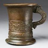 An important signed Enndorfer moratar, An important signed Enndorfer moratar, Cast bronze with slightly mottled brown patina. Tall cylindrical form with flaring rim. Cast with a band of stylised flowerhead motifs above the signature "LVDWIG ENNDORFFER GOS MIC 15 42". One dolphin handle. H 15.3, D