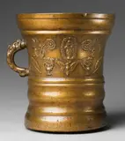 Werkstatt Grassmayr, A large important Grassmayr mortar, Golden yellow bronze with natural patina. Squat, cylindrical vessel with moulded lower section. The centre of the body cast with motifs of the Virgin and Child in an aureola, vases of flowers, winged angel's heads, and sage leaves. With initials "M M" and dated "1687". H 22.2, D