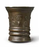 Werkstatt Grassmayr, A dated Grassmayr mortar with a lion's head, Golden brown cast bronze with slightly mottled brown patina. Cast with a series of motifs to the centre: A stylised rose, mascarons, a lion's head, and grotesque figures surrounding the date "1656". With one angular facetted handle. H 16, D