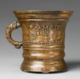 Werkstatt Grassmayr, A dated and inscribed Grassmayr mortar, Golden brown cast bronze with slightly mottled golden bronze patina. Cast with a series of motifs to the centre: Mascarons, flowerheads, naturalistic sage leaves, and angel and cherub mascarons. Dated "1665" below the inscription "MADHIES PRVNER". With horizontal cracks. H 17.2, D