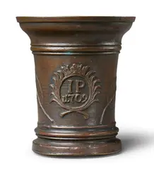 Werkstatt Grassmayr, A dated Grassmayr mortar, Golden brown cast bronze with reddish brown patina. Cast with the initials "IP" and date "1709" in a crowned oval medallion flanked by palm fronds. The sides with large sage leaves. One dolphin handle. H 19.5, D