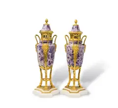 Matthew Boulton, A pair of Blue John potpourri urns, Gilt metal-mounted English carved fluorite vases with berry finials on tripod supports terminating in six hoof feet resting on white marble inswept triangular plinths. Re-gilt, older restorations to both lids. H