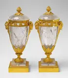 A rare pair of rock crystal potpourri vases in the manner of Pierre Gouthière by A rare pair of rock crystal potpourri vases in the manner of Pierre Gouthière, Opulent ormolu-mounted vases on tiered square plinths of bronze and quartz, the Neoclassical gilt bronze mountings surro, offered Nov 2017