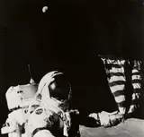 Nasa, Apollo 17, Astronaut Eugene A. Cernan adjusts the flag planted on the Moon, 1973, Gelatin silver print, printed