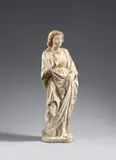 Leonardo Riccomanni, The Angel of the Annunciation by Leonardo Riccomanni, Carrara marble, carved in the round. Older parcel gilding. The Archangel Gabriel is depicted standing on an octagonal plinth with his right foot drawn back, turning to the right, and with his right hand raised in a blessing gesture. The piece has been designed for a frontal viewpoint, and the reverse - especially the back of the head - is only schematically worked whereas the front of the piece displays a masterful treatment of the marble. The sculpture was formerly assigned to Jacopo della Quercia or simply described as a Tuscan work. However, Laura Cavazzini and Aldo Galli were able to attribute it to Leonardo Riccomani – an artist active in Pietrasanta, Lucca, Siena, Naples, and Genoa – with considerable certainty in 1999, dating it to around 1450. Fingers of the right hand partially lost. Minor breakage to one panel of drapery to the centre left. Otherwise with only minimal wear
