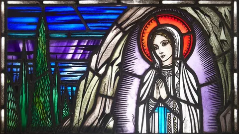 The Studio of Harry Clarke Rha & William J. Dowling, OUR LADY OF LOURDES, 1945, stained glass panel; (presented in wooden frame with light fitting behind)
