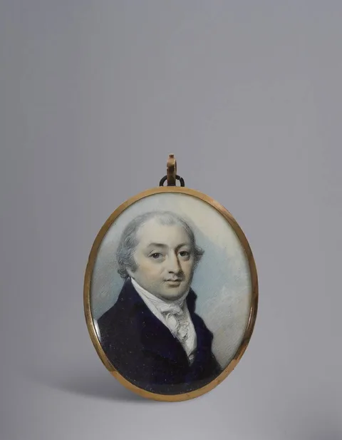 George Engleheart, A GENTLEMAN, WEARING BLUE COAT, WHITE COAT, FRILLED CHEMISE, STOCK AND CRAVAT, HIS HAIR POWDERED, miniature; (Gold frame, the reverse glazed to reveal plaited hair); (oval)