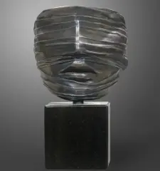 Igor Mitoraj, TWARZ ZAWOALOWANA, 1977, metal srebrzony, czarny marmur