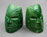 Crown Lynn Wharetana Ware, Pair of 'Moko' bookends, green glazed ceramic