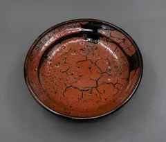 Len Castle, Rimmed bowl, stoneware with crawled terracotta red glaze with crackle and burst bubble effect over tenmoku