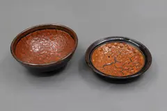 Len Castle, Two small bowls, stoneware with crawled terracotta red glaze over tenmoku ground glaze