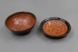 Len Castle, Two small bowls, stoneware with crawled terracotta red glaze over tenmoku ground glaze