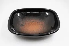 Len Castle, Large rectangular dish, stoneware with tenmoku glaze, thinning to a pool of speckled reddish iron glaze to the centre