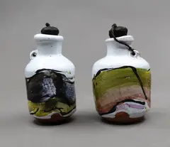 Two rare 'poison' bottles by Chester Nealie, with a heavy white crackled glaze, overpainted with enamels in dark grey, pale green, yellow and taupe hues, with origin, sold Sep 2026