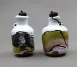 Chester Nealie, Two rare 'poison' bottles, with a heavy white crackled glaze, overpainted with enamels in dark grey, pale green, yellow and taupe hues, with original corks