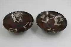 Warren Tippett, Pair of bowls, stoneware, tenmoku glaze with wax resist decoration
