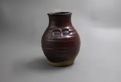 Warren Tippett, Stoneware vase, with persimmon and tenmoku glazes and decorated with impressed seal markings of stylised leaf design