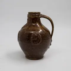 Graeme Storm, Bellarmine, brown glazed stoneware with applied bearded mask and armorial type panels, 1980's