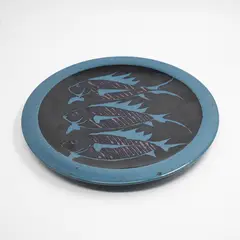 Peter Stichbury, Large round wall platter, with blue wax resist decoration depicting three fish on a black ground