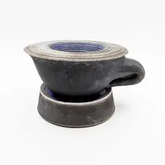 David Howard Jones, Sculptural oversize cup and saucer, raku fired earthenware with smooth matt black surface and dark blue glazed highlights