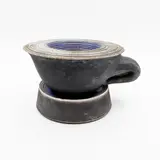 David Howard Jones, Sculptural oversize cup and saucer, raku fired earthenware with smooth matt black surface and dark blue glazed highlights