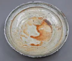 Low profile bowl by Len Castle, shino glazed stoneware, with orange highlights and carbon inclusions, the glaze with crackle effect, ca. 1980's, sold Jun 2026
